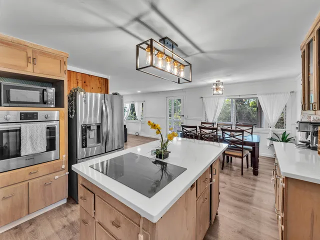 a kitchen with stainless steel appliances granite countertop a sink a stove and a refrigerator