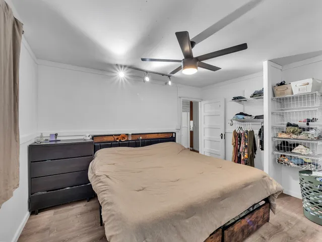 a bed sitting in a bedroom and view of kitchen