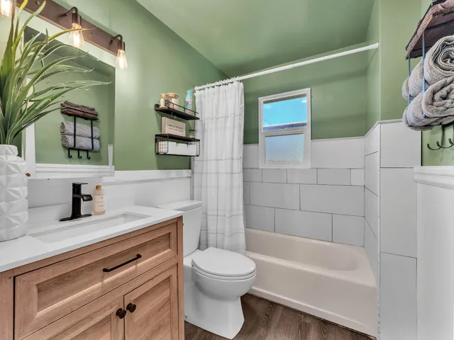 a bathroom with a granite countertop sink a toilet and bathtub