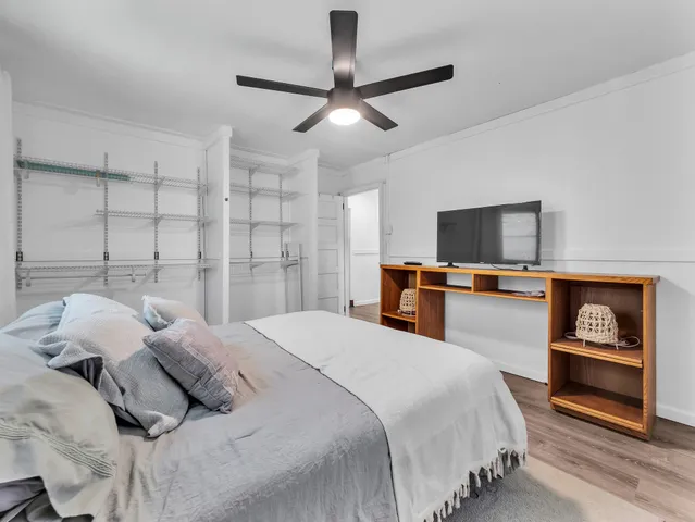 a bedroom with a bed and a tv on the dresser