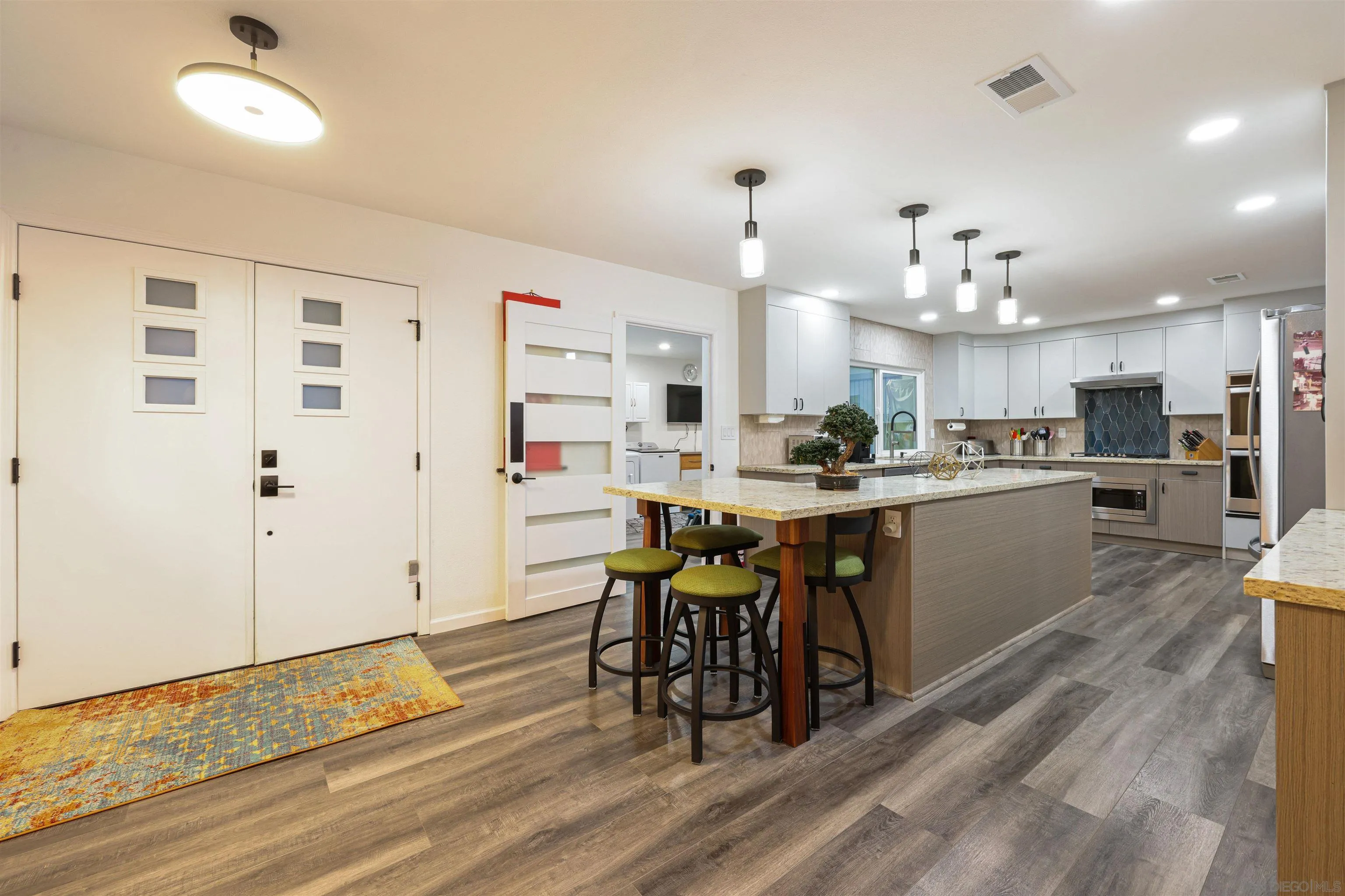 4016 Via Rio Avenue Oceanside, CA 92057 - Photo 3 of 34 a kitchen with stainless steel appliances kitchen island granite countertop a table chairs and a refrigerator