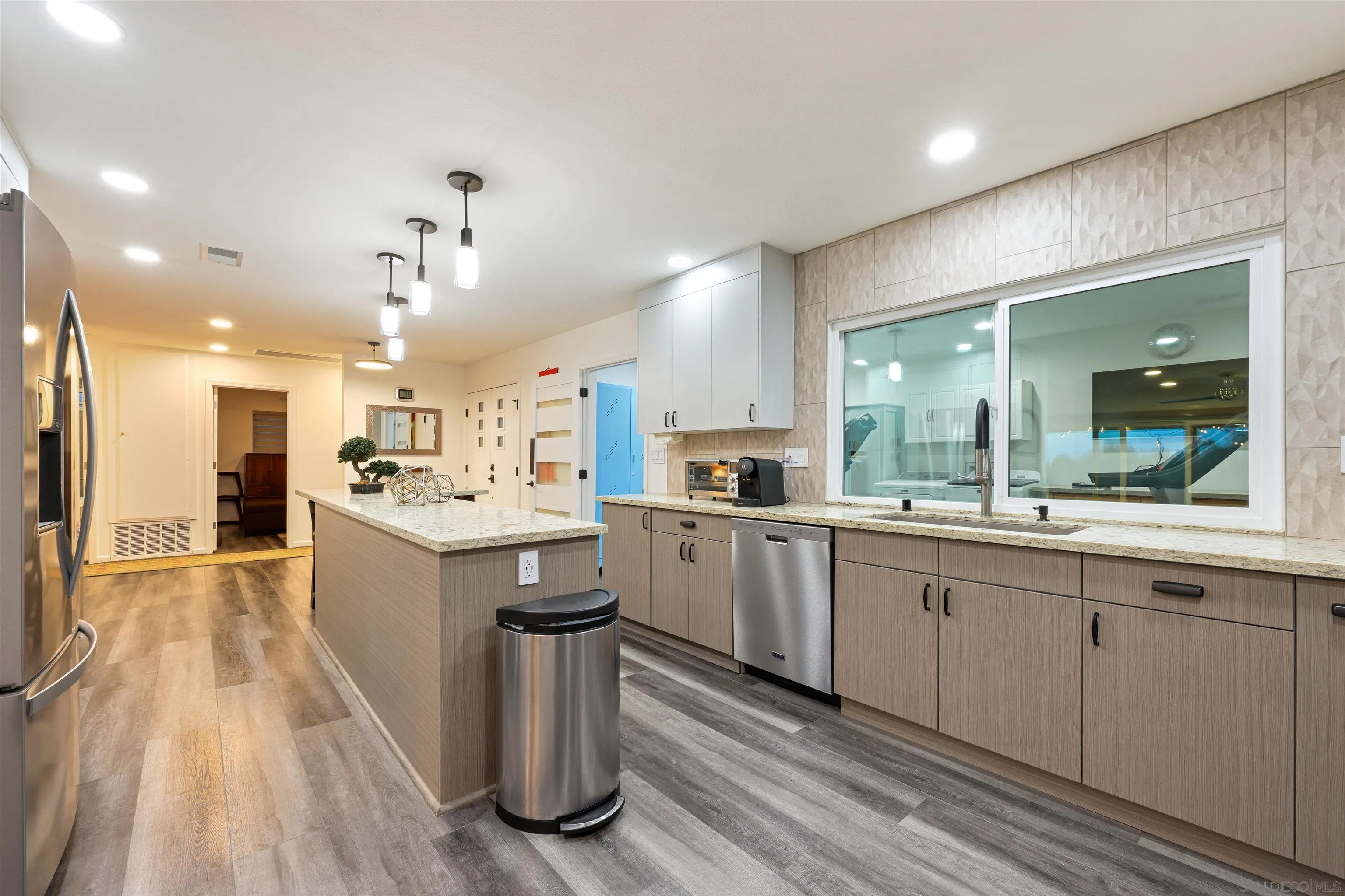 4016 Via Rio Avenue Oceanside, CA 92057 - Photo 7 of 34 a large kitchen with kitchen island a sink white cabinets and wooden floor