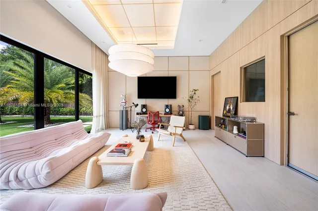 a large white kitchen with kitchen island a large counter top space a sink a couch and a window