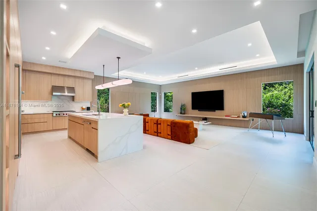 a living room with patio furniture and a flat screen tv