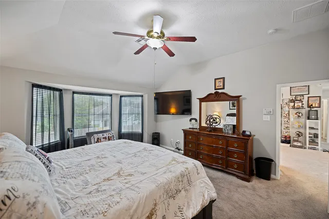 a bedroom with a bed and dresser with mirror
