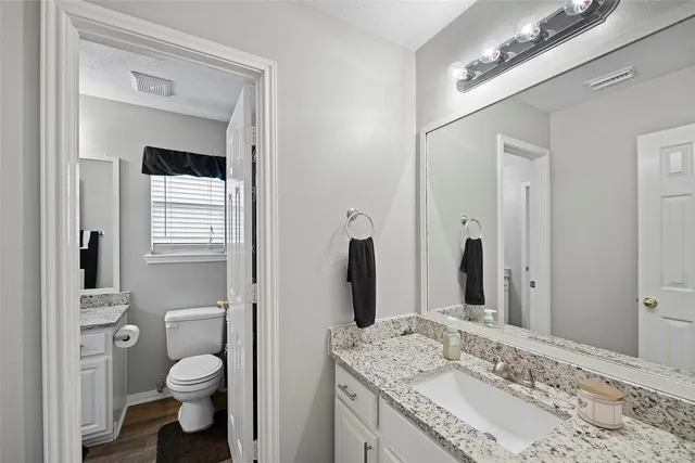 a bathroom with a granite countertop sink toilet and shower