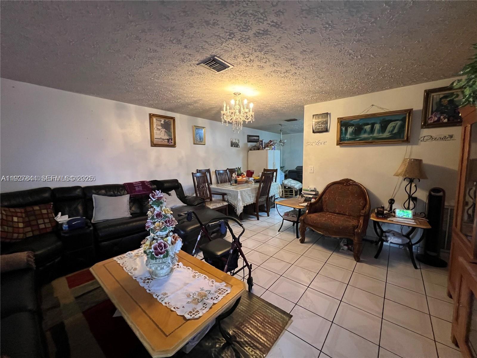1581 Northeast 117th Street Miami, FL 33161 - Photo 25 of 29 a living room with furniture a rug and a table