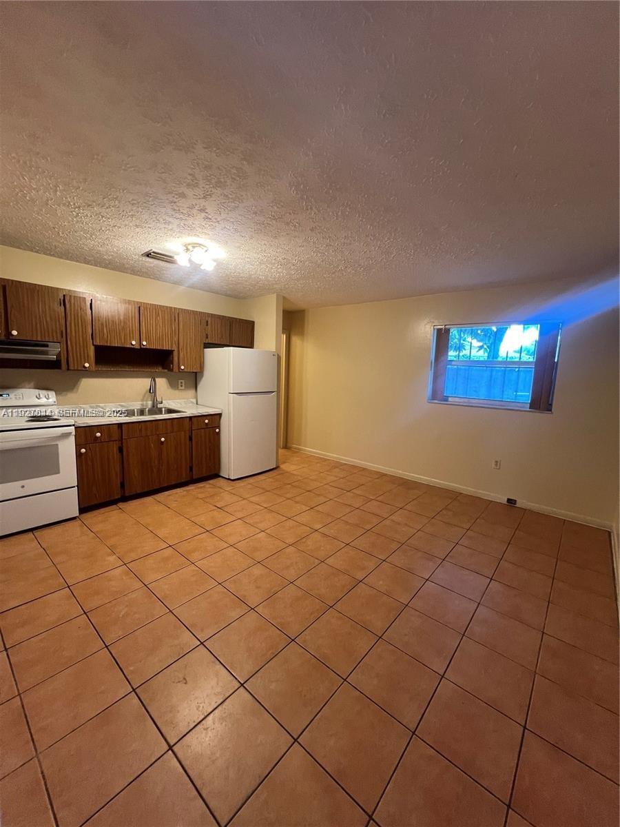 1581 Northeast 117th Street Miami, FL 33161 - Photo 6 of 29 a kitchen with stainless steel appliances a refrigerator and a stove top oven