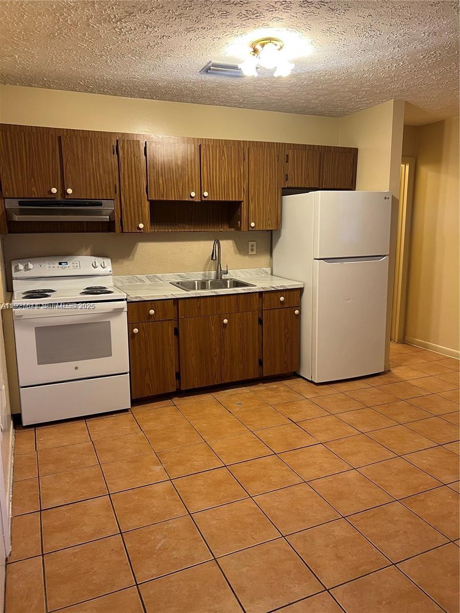 1581 Northeast 117th Street Miami, FL 33161 - Photo 8 of 29 a kitchen with stainless steel appliances granite countertop a stove a sink dishwasher and a refrigerator
