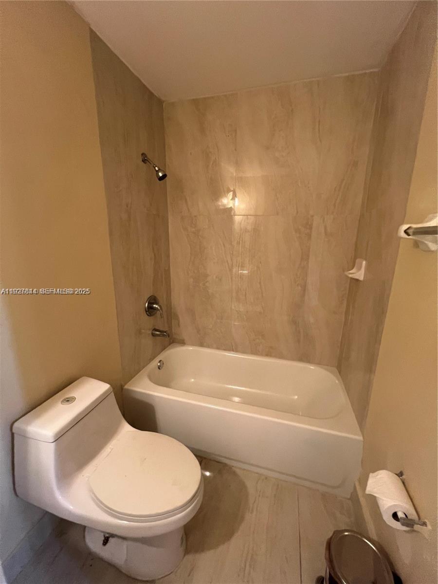 1581 Northeast 117th Street Miami, FL 33161 - Photo 10 of 29 a white toilet sitting next to a bath tub