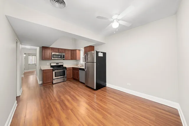 a kitchen with stainless steel appliances wooden floor and cabinets