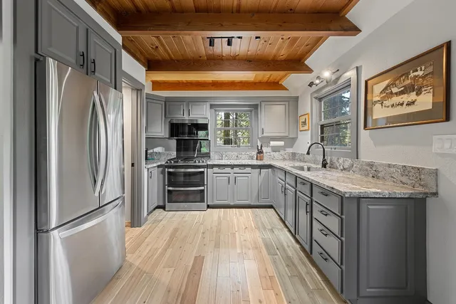 a kitchen with stainless steel appliances granite countertop a refrigerator a sink and a stove