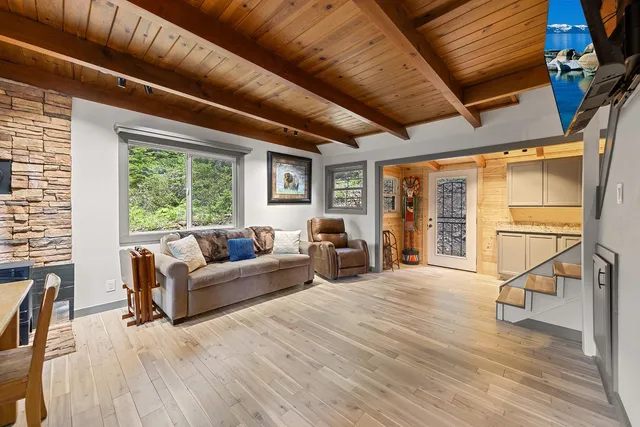 a living room with furniture a flat screen tv and a large window