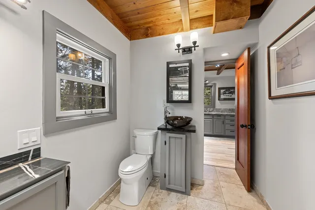 a bathroom with a toilet a sink and a window