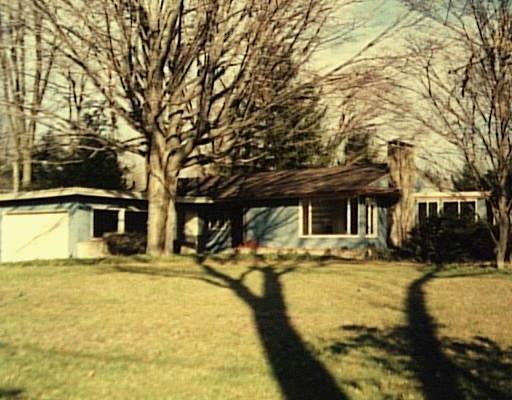 a front view of a house with swimming pool and sitting area