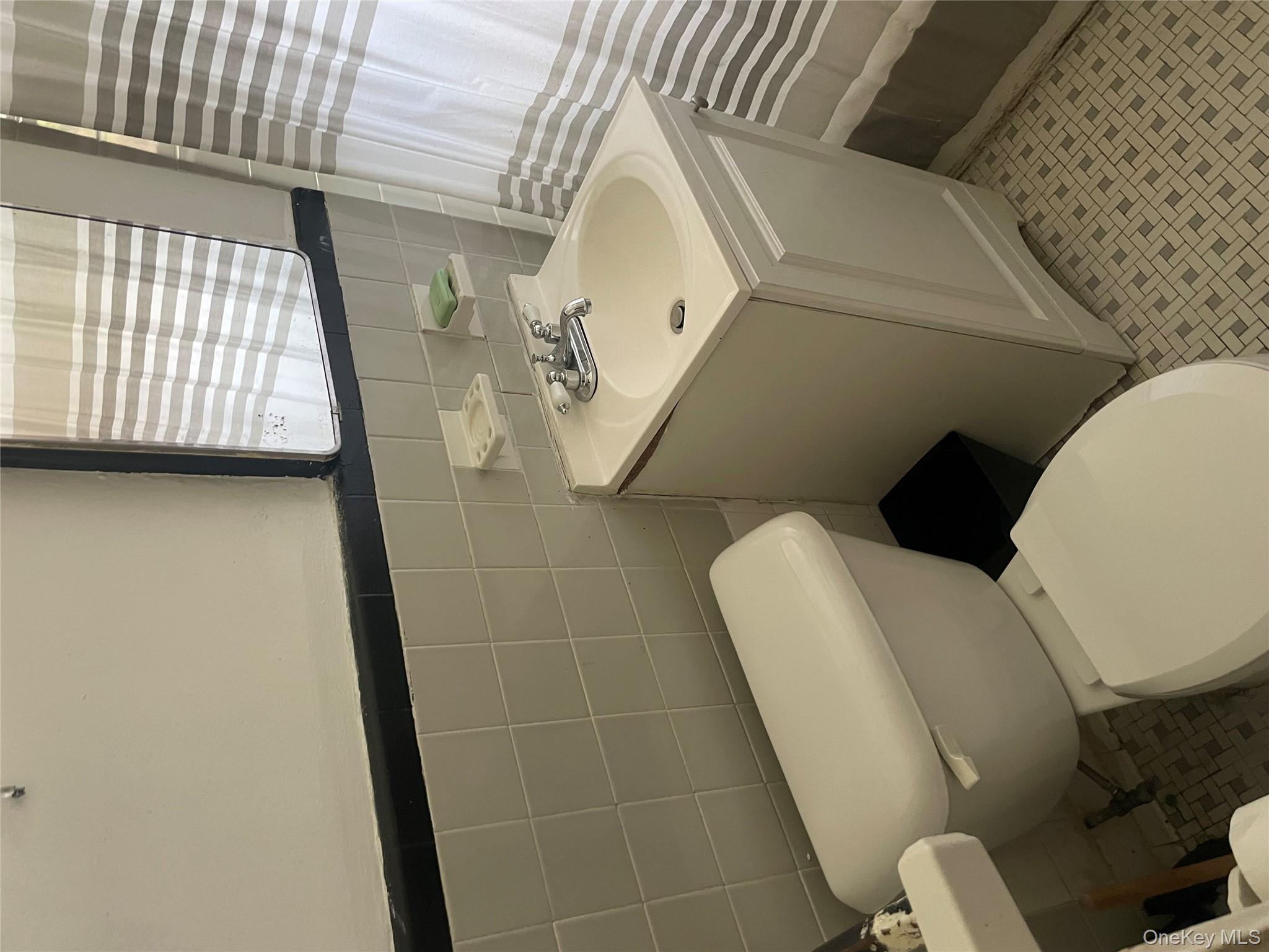 5614 Netherland Avenue, Unit 4A Bronx, NY 10471 - Photo 10 of 19 a white toilet sitting next to a bathroom sink