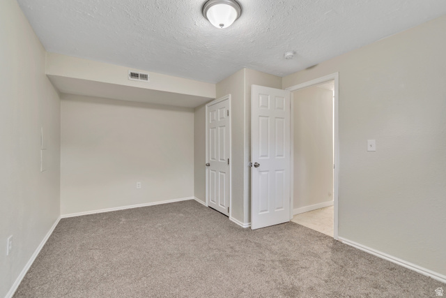 1118 North Ridge Court Spanish Fork, UT 84660 - Photo 31 of 32 Unfurnished bedroom with light carpet, a textured ceiling, and a closet
