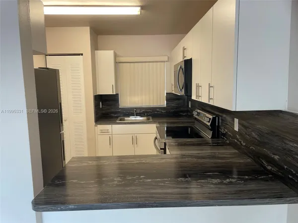 a kitchen with stainless steel appliances granite countertop a stove a refrigerator and a sink