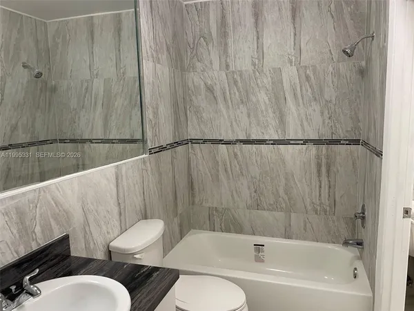 a bathroom with a sink mirror toilet and bathtub