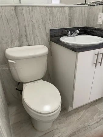 a white toilet sitting next to a white sink