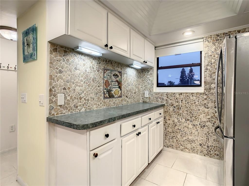 18304 Gulf Boulevard, Unit 116 Redington Shores, FL 33708 - Photo 11 of 51 a bathroom with a granite countertop sink a mirror and shower