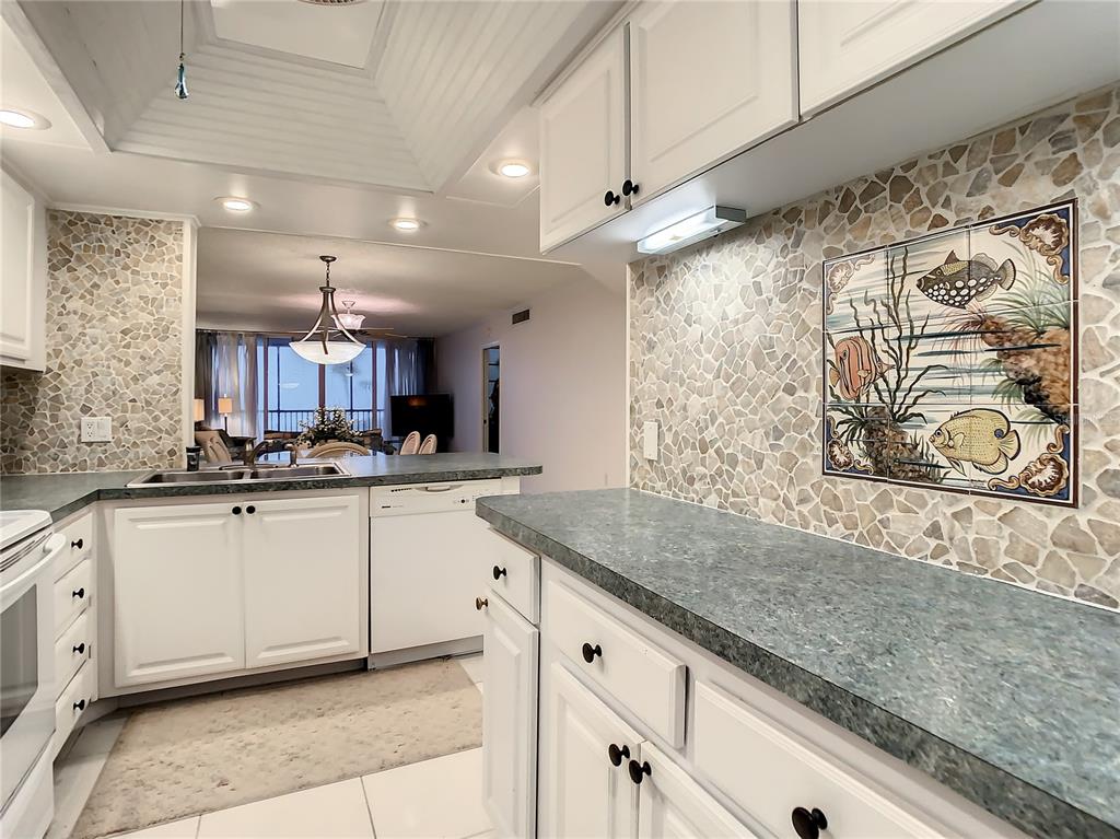 18304 Gulf Boulevard, Unit 116 Redington Shores, FL 33708 - Photo 14 of 51 a kitchen with stainless steel appliances granite countertop a sink a granite counter tops and a view of living room