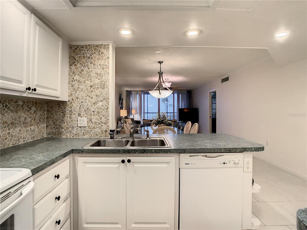 18304 Gulf Boulevard, Unit 116 Redington Shores, FL 33708 - Photo 15 of 51 a kitchen with stainless steel appliances granite countertop a sink a stove and cabinets