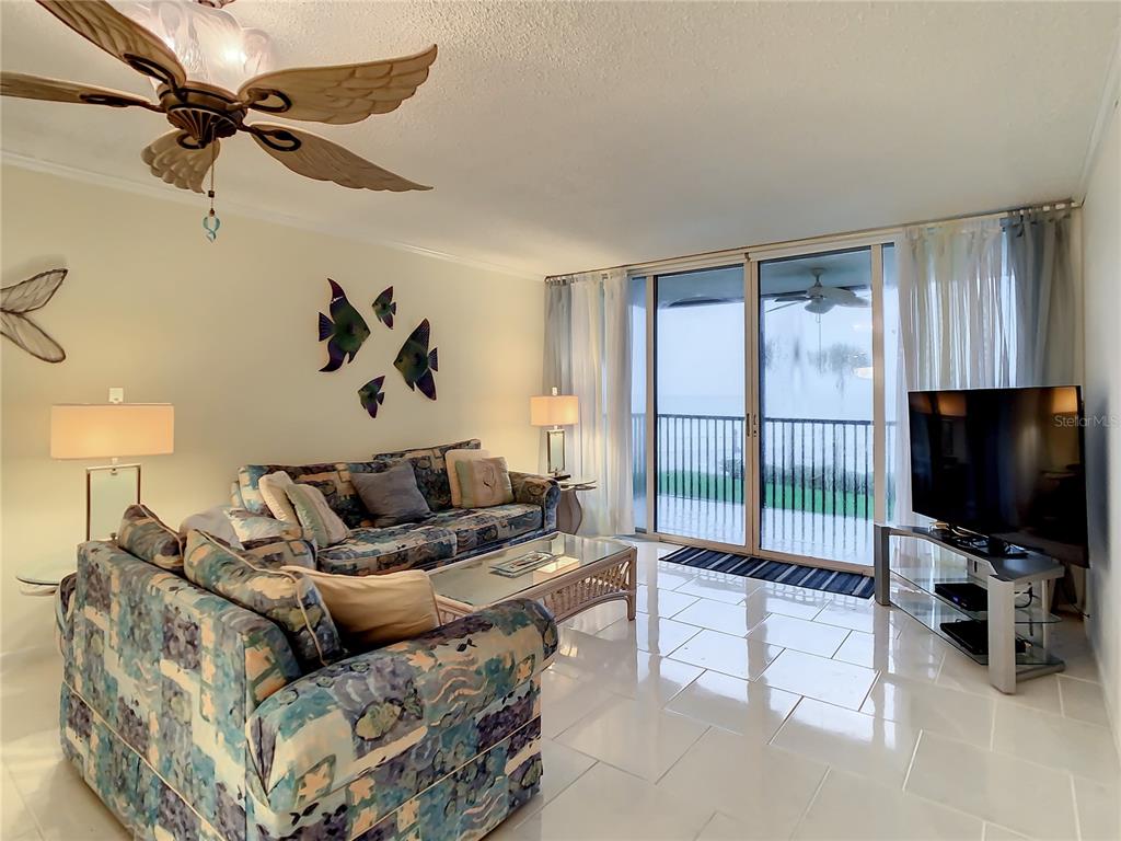 18304 Gulf Boulevard, Unit 116 Redington Shores, FL 33708 - Photo 21 of 51 a living room with furniture and a flat screen tv
