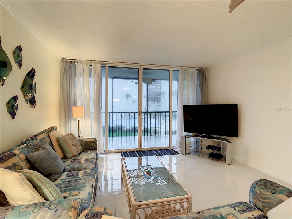 18304 Gulf Boulevard, Unit 116 Redington Shores, FL 33708 - Photo 22 of 51 a living room with furniture and a flat screen tv
