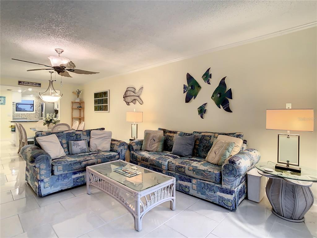 18304 Gulf Boulevard, Unit 116 Redington Shores, FL 33708 - Photo 24 of 51 a living room with furniture and a lamp