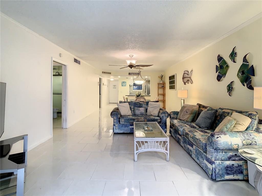18304 Gulf Boulevard, Unit 116 Redington Shores, FL 33708 - Photo 25 of 51 a living room with furniture and a chandelier