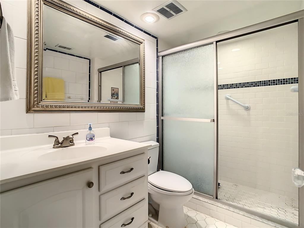 18304 Gulf Boulevard, Unit 116 Redington Shores, FL 33708 - Photo 31 of 51 a bathroom with a shower sink vanity mirror and toilet