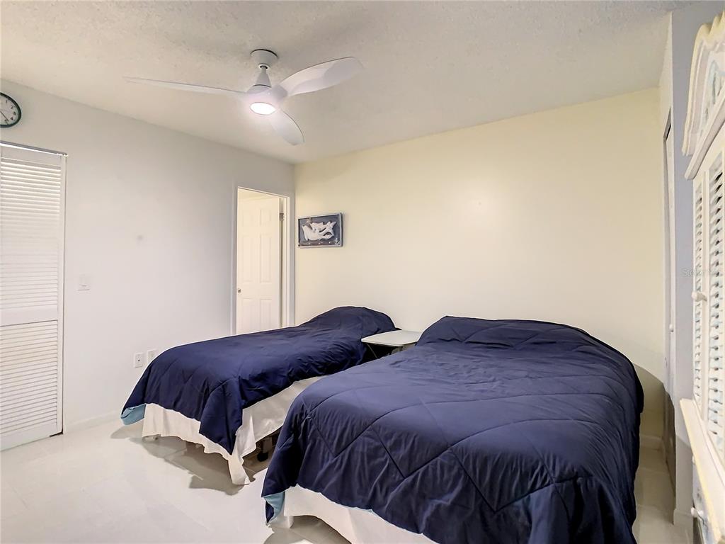 18304 Gulf Boulevard, Unit 116 Redington Shores, FL 33708 - Photo 35 of 51 a bedroom with a bed and a night stand