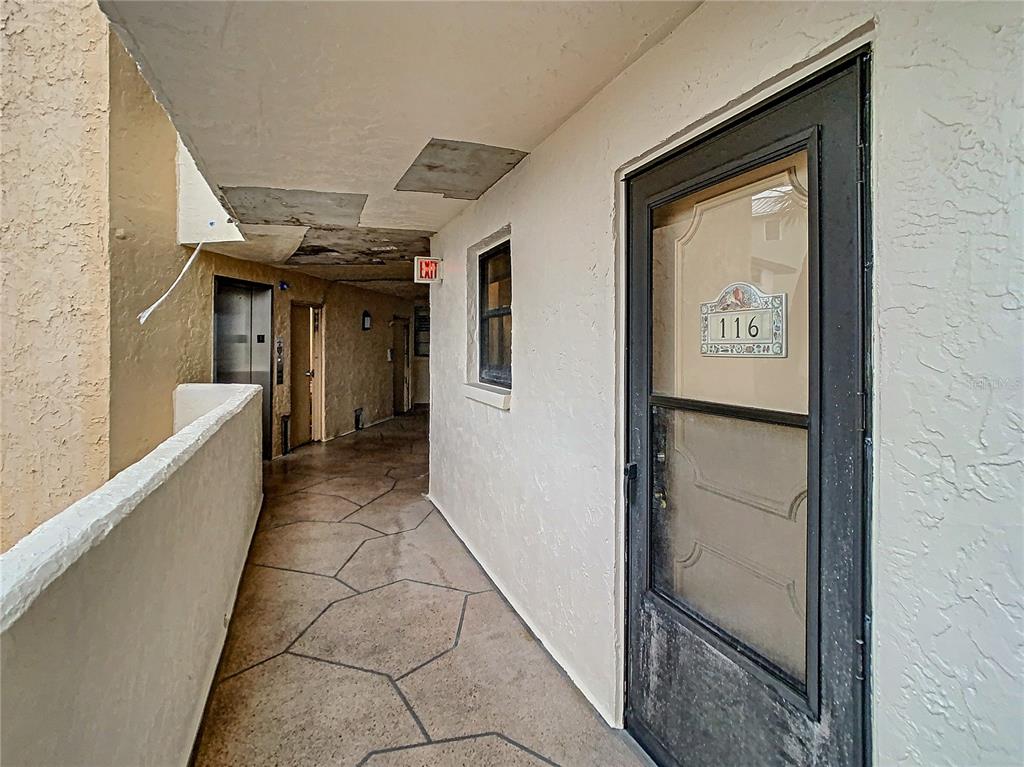 18304 Gulf Boulevard, Unit 116 Redington Shores, FL 33708 - Photo 7 of 51 a hallway with painting on the wall