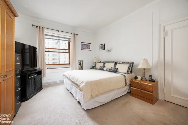 a spacious bedroom with a bed a couch and a window