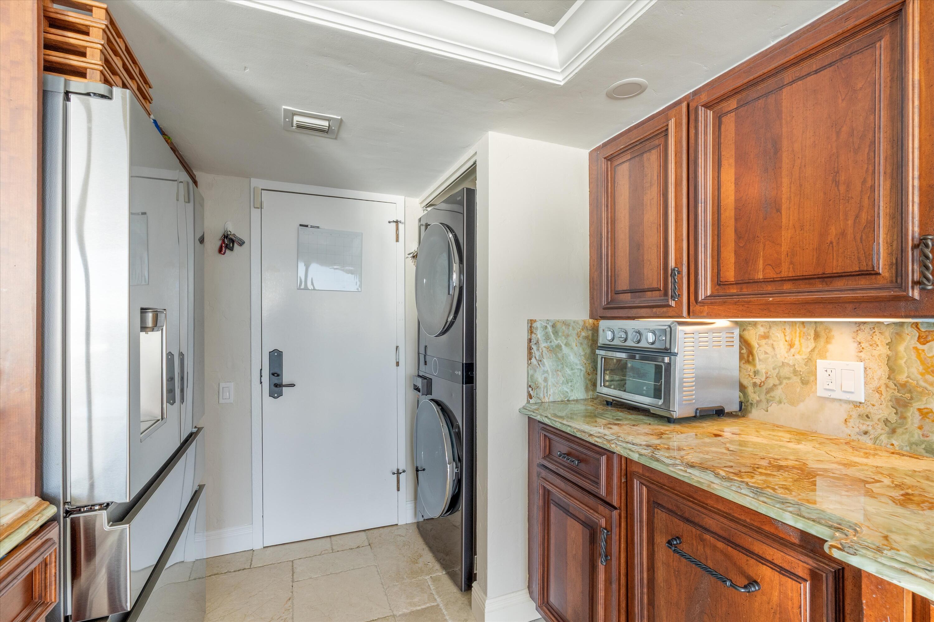 250 South Ocean Boulevard, Unit 14E Boca Raton, FL 33432 - Photo 9 of 27 a kitchen with granite countertop a refrigerator and a sink