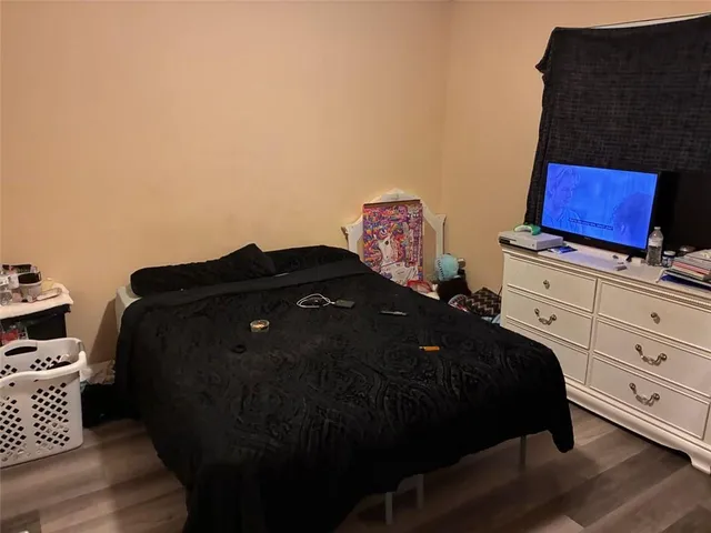 a bed sitting in a bedroom next to a window with wooden floor