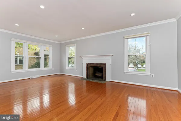 a view of empty room with wooden floor and fireplace