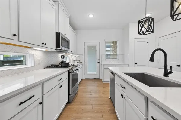 a kitchen with cabinets a sink and appliances