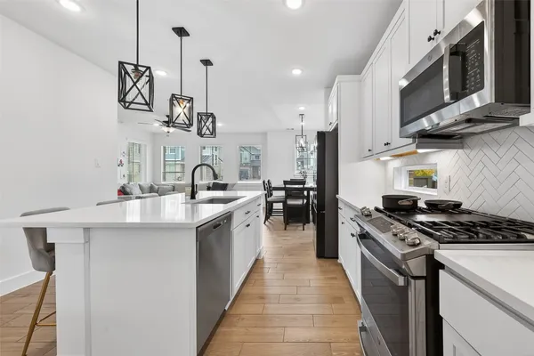 a kitchen with stainless steel appliances a sink stove and cabinets