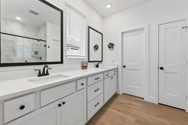 a bathroom with a double vanity sink and mirror