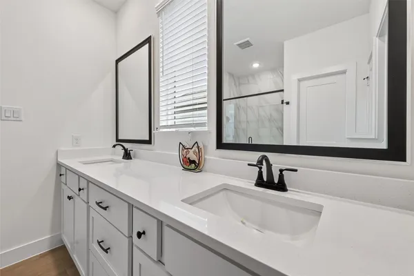 a bathroom with double sink and a mirror