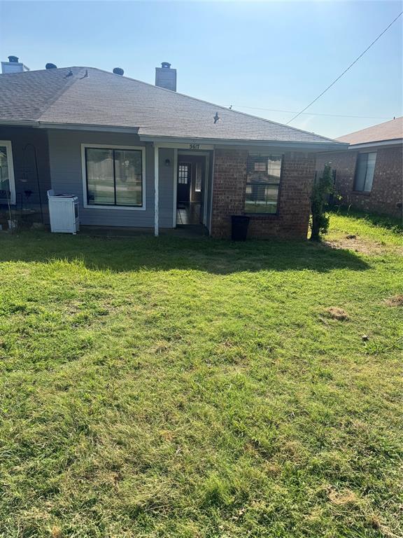 5617 Mansfield Road Arlington, TX 76017 - Photo 3 of 15 Front exterior featuring a spacious lawn, brick and siding facade, covered patio, and shingle roof