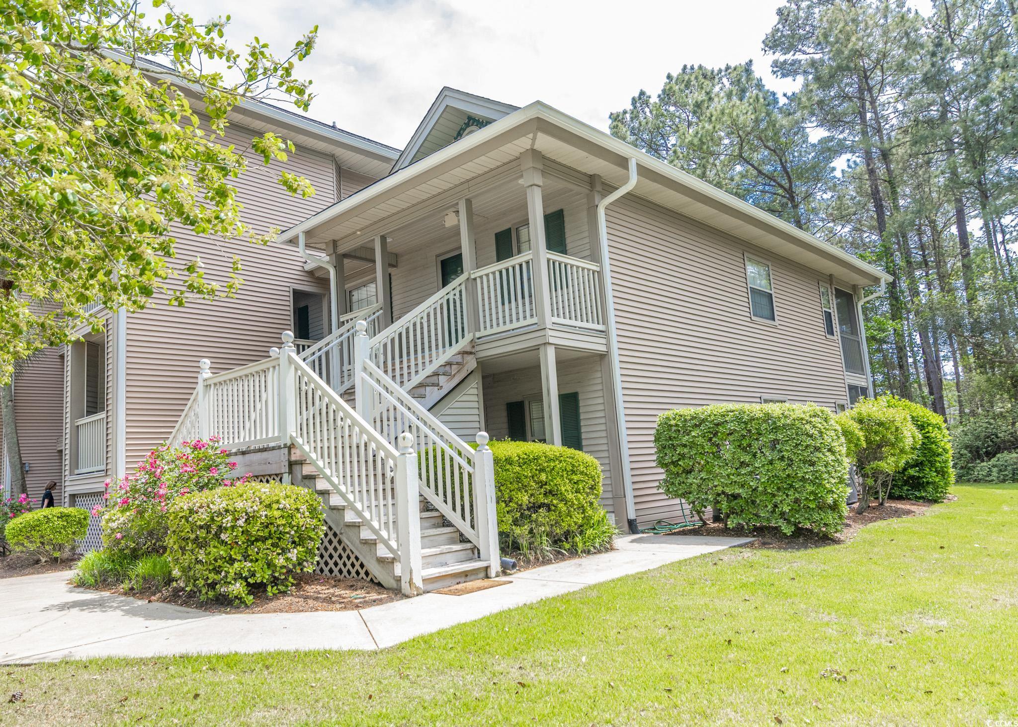 227 Pinehurst Lane, Unit 6D Pawleys Island, SC 29585 - Photo 1 of 39 View of side of home featuring a lawn, stairway, and covered porch