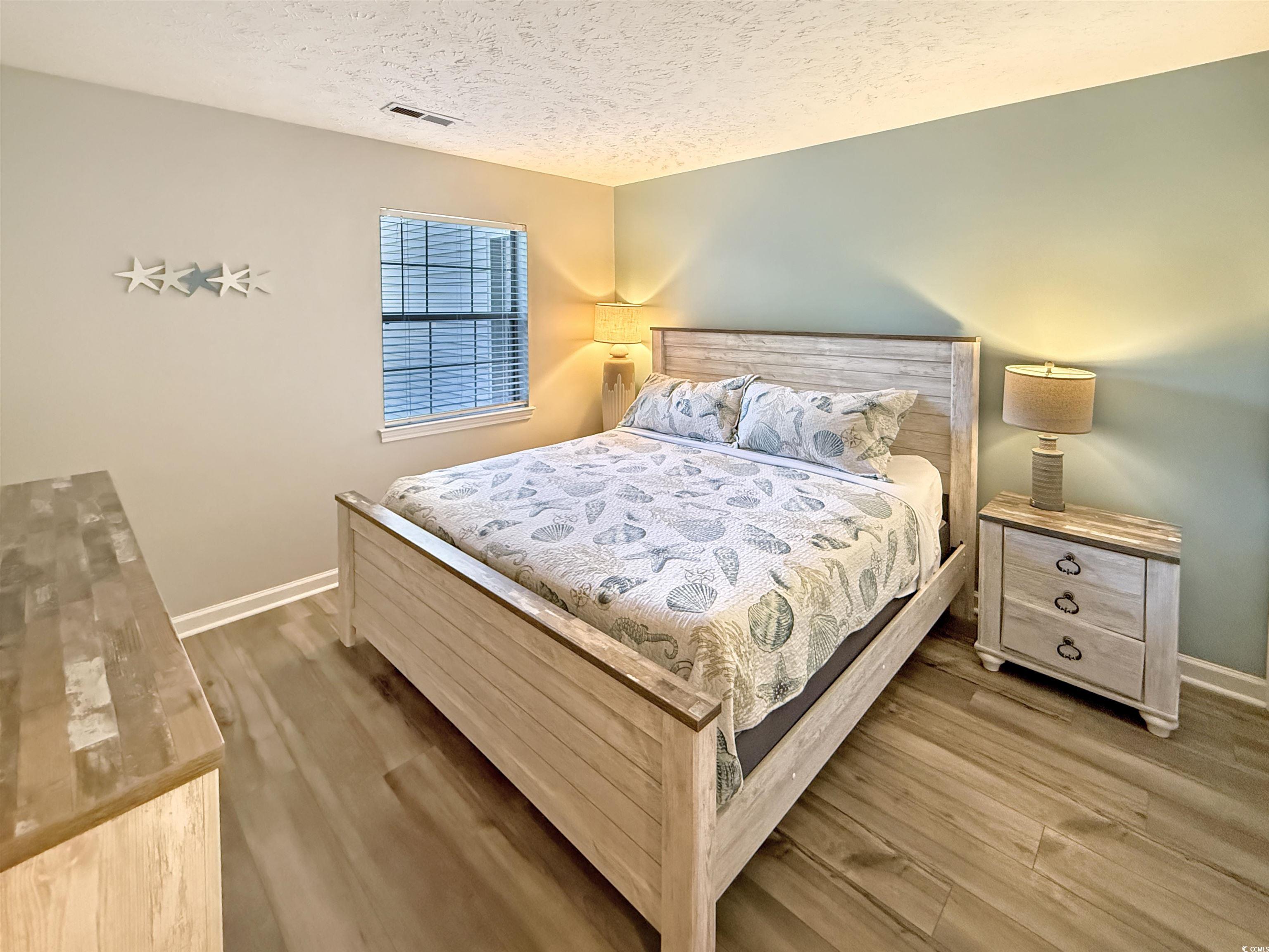 227 Pinehurst Lane, Unit 6D Pawleys Island, SC 29585 - Photo 31 of 39 Bedroom featuring a textured ceiling and light wood-style flooring