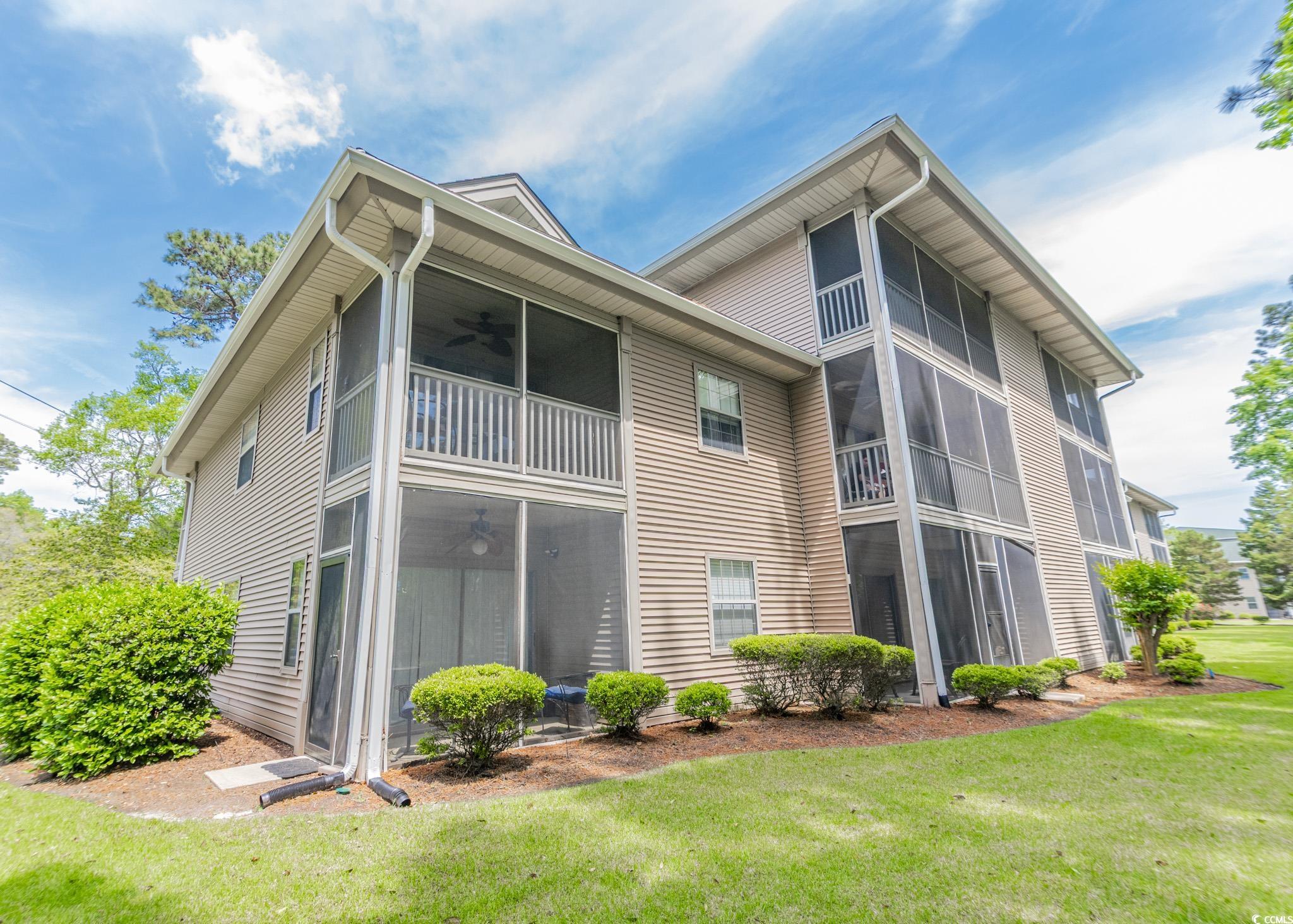 227 Pinehurst Lane, Unit 6D Pawleys Island, SC 29585 - Photo 4 of 39 Rear view of property featuring a lawn, a sunroom, and a ceiling fan