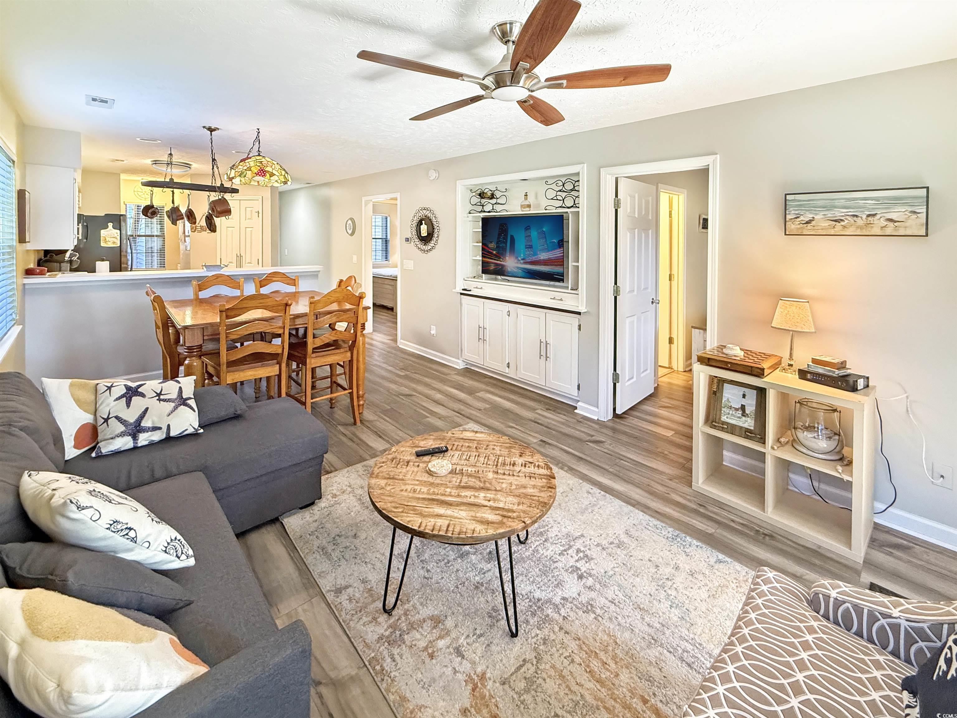 227 Pinehurst Lane, Unit 6D Pawleys Island, SC 29585 - Photo 6 of 39 Living area with light wood-style floors, ceiling fan, and a textured ceiling