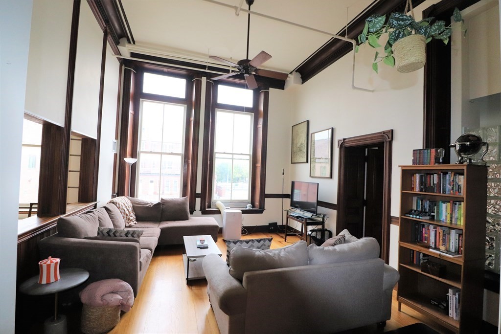 172 Middle Street, Unit 210 Lowell, MA 01852 - Photo 3 of 28 a living room with furniture a flat screen tv and a large window