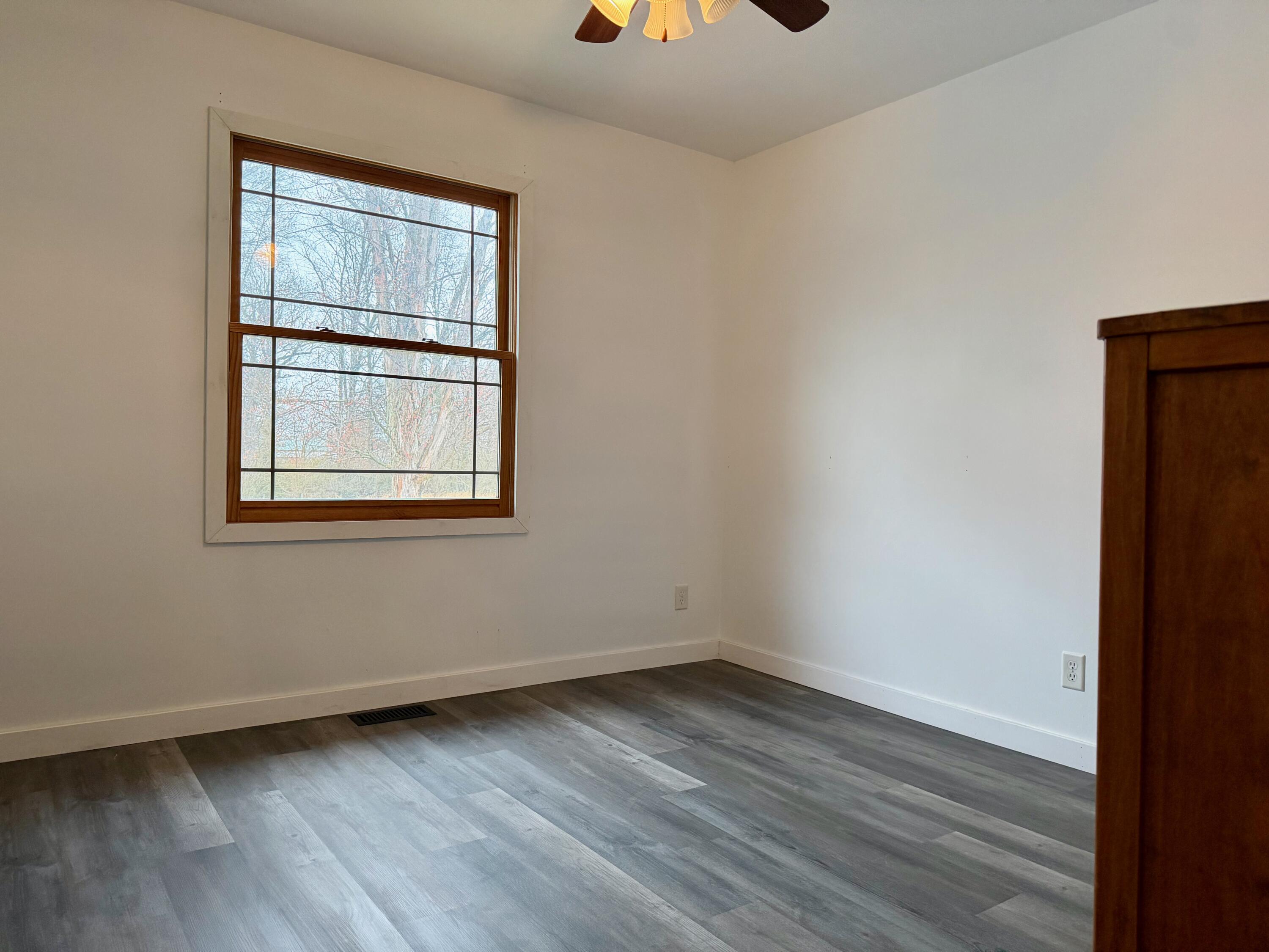 5850 West 600 North Winamac, IN 46996 - Photo 12 of 28 an empty room with wooden floor and windows