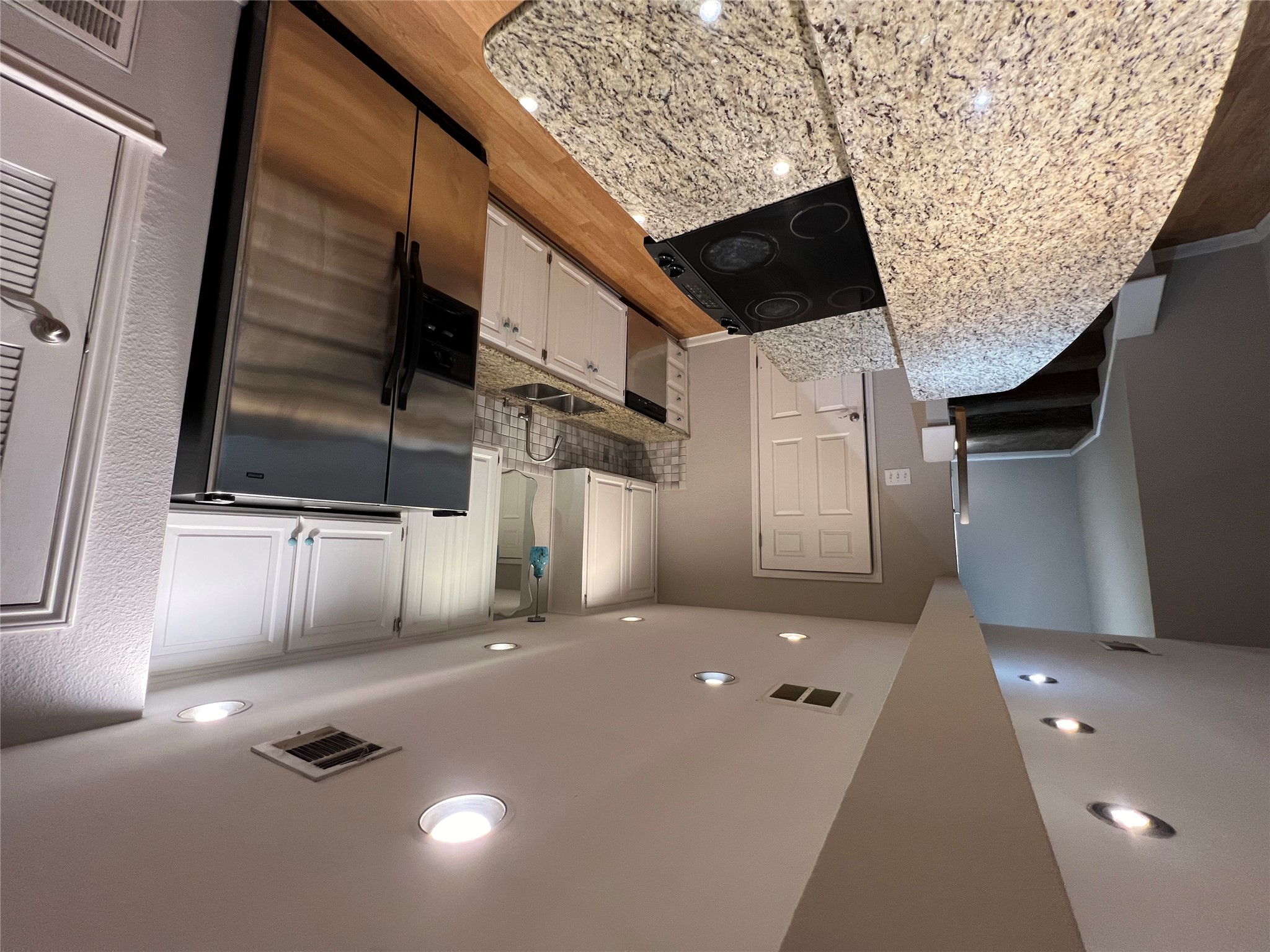 a large kitchen with a sink and stainless steel appliances